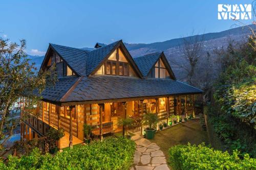 a large house with a black roof at StayVista at The Manor with Mountain View & Fireplace in Manāli