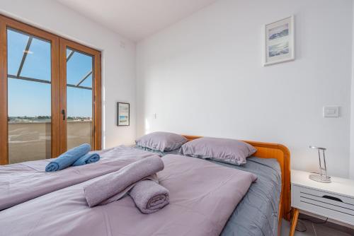 a bedroom with a bed with two pillows on it at See the Sea in Nin