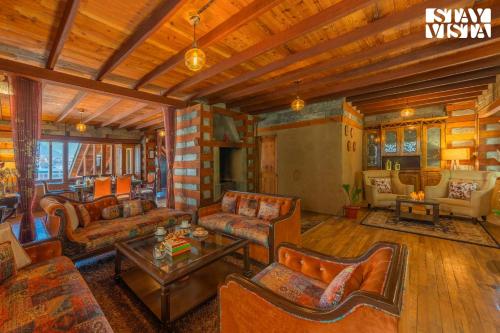 a living room with couches and a table at StayVista at The Manor with Mountain View & Fireplace in Manāli