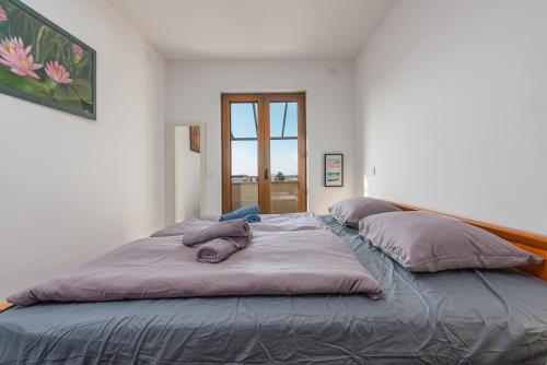 a large bed in a room with pillows on it at See the Sea in Nin