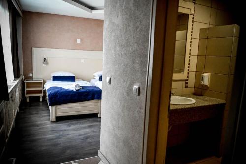 a bedroom with a bed and a bathroom with a sink at Hotel Centar Balasevic in Belgrade