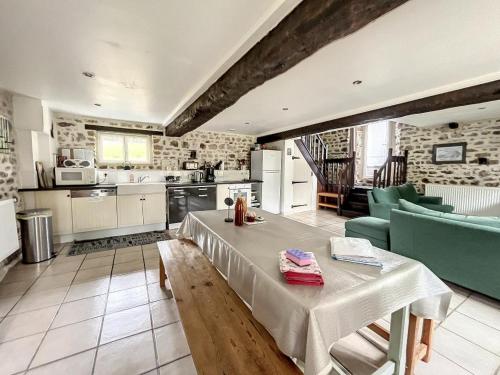 - une cuisine avec une table, des chaises et une table dans l'établissement Meublé de Tourisme La Clef des Champs Normandie Manche, à Montpinchon