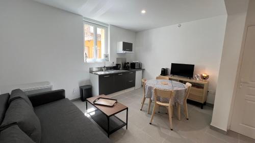a living room with a couch and a table at Fenix Appartement T2 40 M2 cosy RDC plein centre ville in Pierrelatte