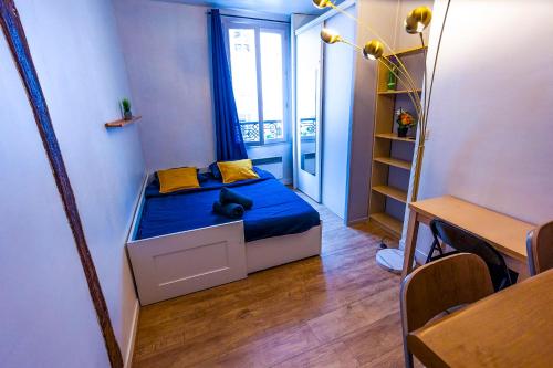 Cette petite chambre comprend un lit avec une couverture bleue. dans l'établissement Cosy Beautiful Studio Heart of Paris Saint-Germain des Prés, à Paris