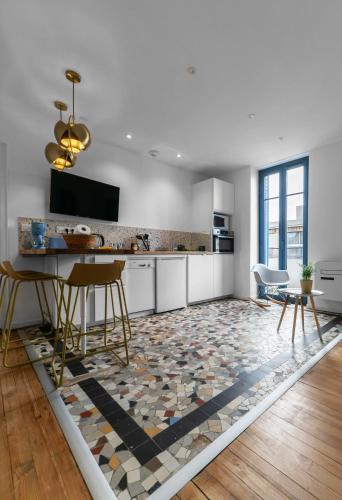 une cuisine avec une table et des chaises sur un tapis dans l'établissement Le Petillat - Appartement design en centre ville, à Vichy