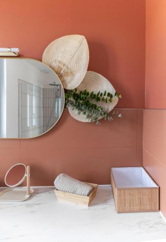 une salle de bain avec un miroir et un lavabo dans l'établissement Le Petillat - Appartement design en centre ville, à Vichy
