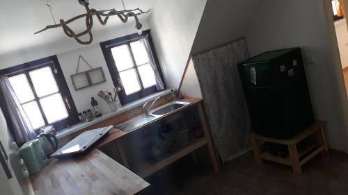 una cucina con un lavello, un bancone e due finestre di FeWo EselGlück Wälder Berge Seen Ruhe Naturidylle zw Bautzen Zittau Görlitz - Oberlausitz a Melaune
