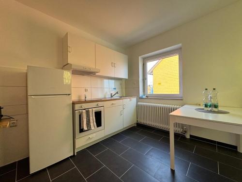 a kitchen with a white refrigerator and a table at Zentral gelegene Unterkunft in Kiel in Kiel