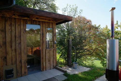 a wooden shed with a large glass door at Wohlfühlhaus mit großem Garten in Zgornja Kungota