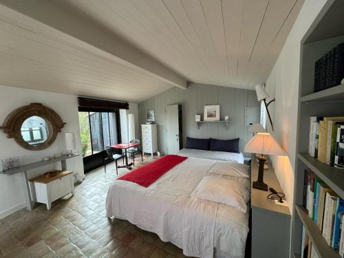 um quarto com uma cama com um cobertor vermelho em Ma Chambre d'Amis em Saint-Clément-des-Baleines