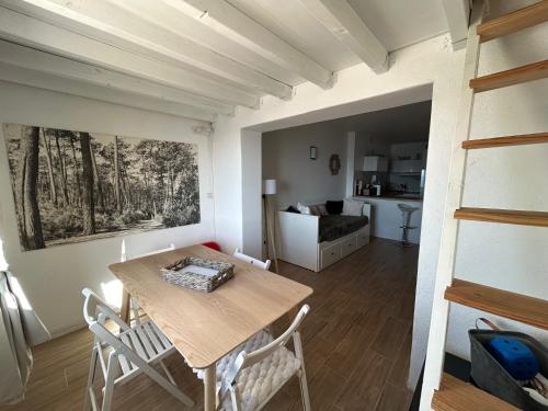 une salle à manger avec une table et des chaises et une cuisine dans l'établissement Studio les pieds dans l eau au Brusc 4 personnes, à Six-Fours-les-Plages