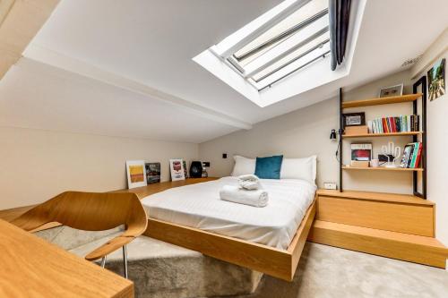 um quarto com uma cama e uma clarabóia em L'architecte - Design & Luxueux em Paris