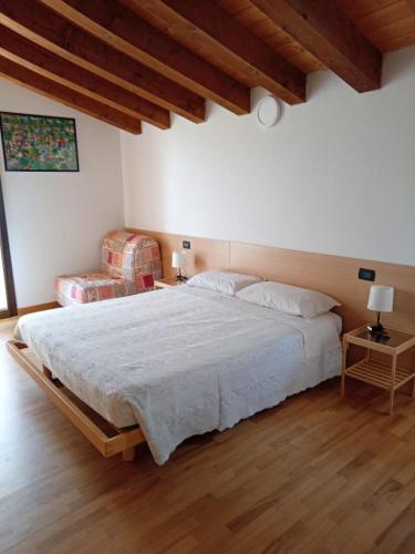 a bedroom with a large bed and wooden floors at La Colombara in Fara Vicentino