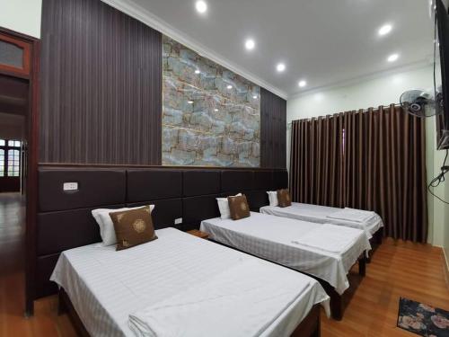 1 dormitorio con 2 camas y un cuadro en la pared en Khách sạn Thùy Dương 2, en Bảo Lạc