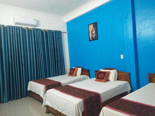 Habitación con 2 camas y pared azul en Khách sạn Thùy Dương 2 en Bảo Lạc