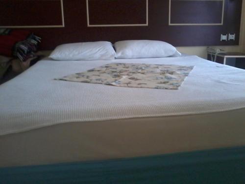 a bed with a white bedspread with a rug on it at Hamle Hotel in Akyaka