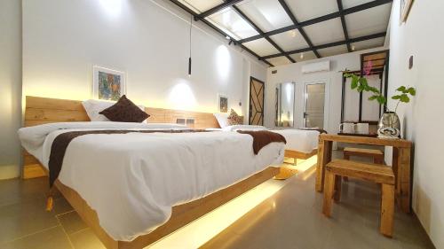 a bedroom with a large bed and a table at Cool Home Office, Sihanoukville in Sihanoukville