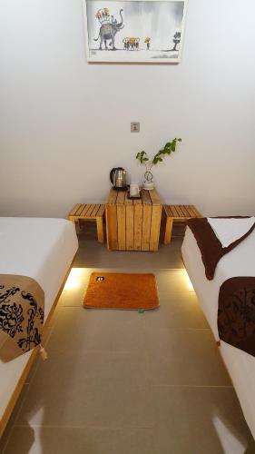 a room with two beds and a table in it at Cool Home Office, Sihanoukville in Sihanoukville