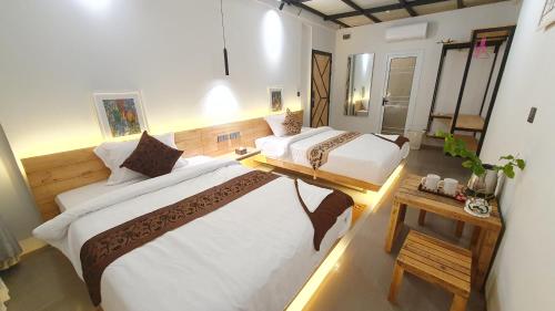 1 dormitorio grande con 2 camas y mesa en Cool Home Office, Sihanoukville, en Sihanoukville