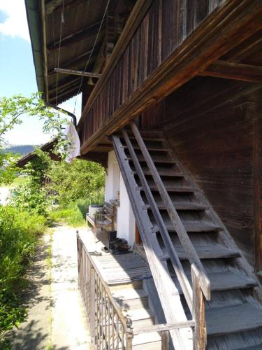 un escalier en bois sur le côté du bâtiment dans l'établissement Dachstockzimmer in altem Stöckli, à Steffisburg