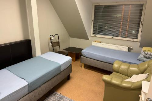 Rotermanni hostel 4Floor NO LIFT في تالين: غرفة نوم بسريرين واريكة وكرسي