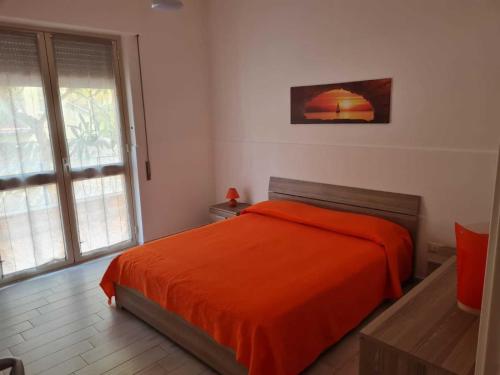 a bedroom with a bed with an orange blanket at The Dreams House Mondello in Mondello