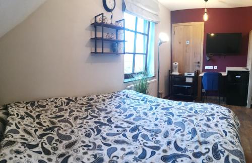 a bedroom with a bed with a blue and white bedspread at Gîte coquet 2 chambres, 2 salles de douches avec piscine, spa in Namur
