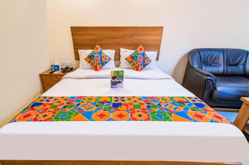 Un dormitorio con una cama con una colcha colorida. en FabHotel Jansi Deluxe Gandhipuram, en Coimbatore