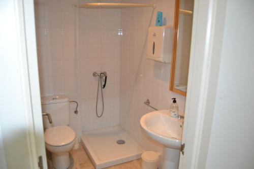y baño con ducha, aseo y lavamanos. en Albergue Internacional, en Sarria