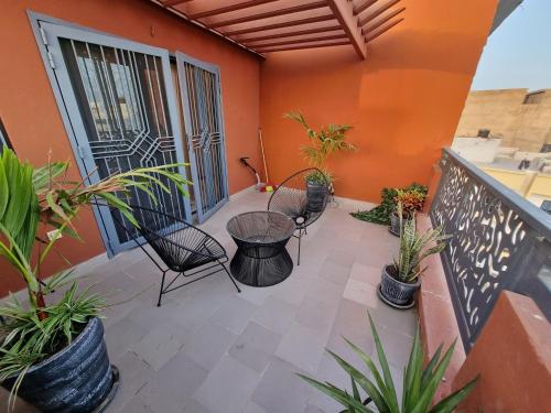 a balcony with a table and chairs and plants at Keur Buur in Dakar