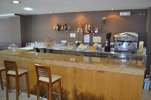 a bar with two chairs and a counter top at Albergue Internacional in Sarria