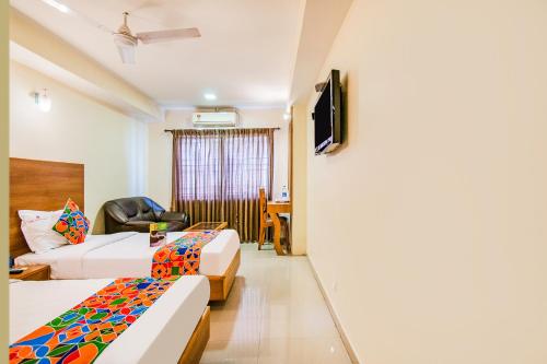 a hotel room with two beds and a tv at FabHotel Jansi Deluxe - Nr Gandhipuram Bus stand in Coimbatore