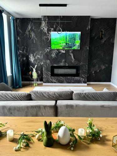 ein Wohnzimmer mit einem Sofa und einem TV in der Unterkunft LV Luxury Apart - One minute away from train station in Predeal