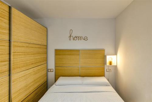 un dormitorio con una cama con la palabra hogar encima en Sea-CHIC Appartement, en Empuriabrava