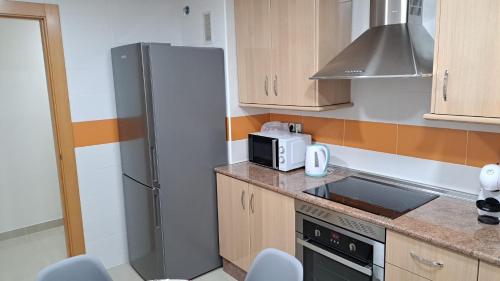 a kitchen with a refrigerator and a microwave at Apartamento Romero in Caravaca de la Cruz