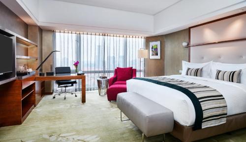 a hotel room with a large bed and a desk at InterContinental Shanghai Pudong by IHG in Shanghai