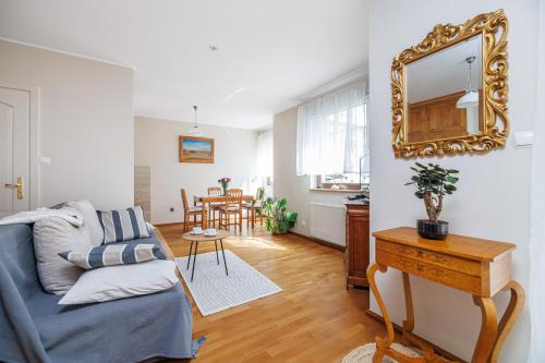 a living room with a couch and a mirror at Lapwing Apartments - Comfort in Sopot