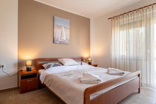 a bedroom with a bed with two towels on it at Apartment Wish - two bedrooms with 2 AC renewed in Pag