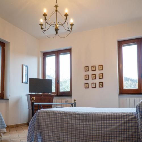 a bedroom with a bed and a tv and windows at Agriturismo Casale Piè d'Eco in Calvanico