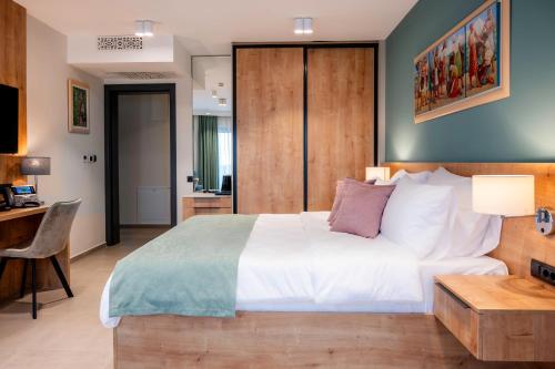 a bedroom with a large white bed and a desk at Dve Kule Resort & Winery in Bačinci