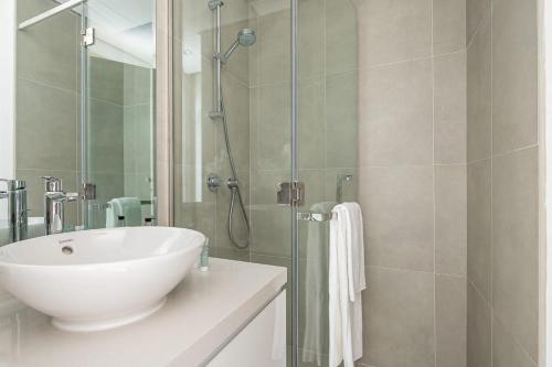 bagno con lavandino bianco e doccia di Frank Porter - Studio One a Dubai