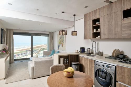 a kitchen and living room with a table in a kitchen at Sea View & Hassan 2 Mosque By TheCasaEdition (B18) in Casablanca