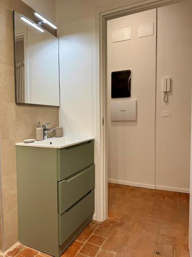 a bathroom with a sink and a mirror and a door at Casa Viaggi in Castel Guelfo di Bologna