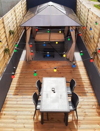 d'une terrasse avec une table et des chaises. dans l'établissement Maisonnette & Jacuzzi, à Saint-Valery-sur-Somme