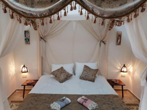 um quarto com uma cama branca e 2 almofadas em 1001-Nights Palace 