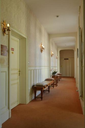 a hallway with a row of benches in a building at Hotel Castel Jeanson in Ay