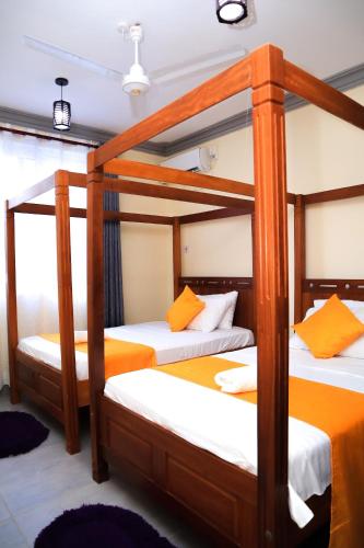 two bunk beds in a room with orange and white at Pavillion Suites, pazuri Homes in Nyali