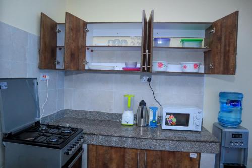 a kitchen counter with a stove and a microwave at Pavillion Suites, pazuri Homes in Nyali