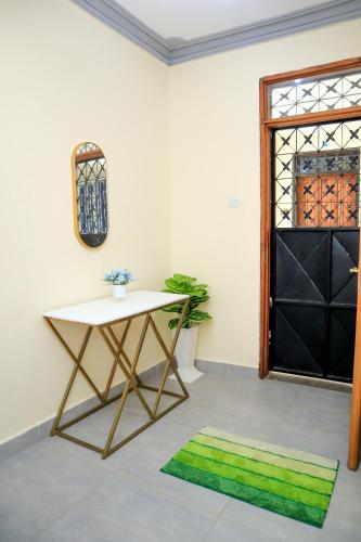 a table and a green rug in a room with a window at Pavillion Suites, pazuri Homes in Nyali