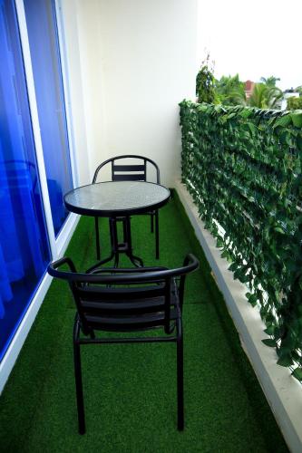 a table and chairs on a balcony with green plants at Pavillion Suites, pazuri Homes in Nyali